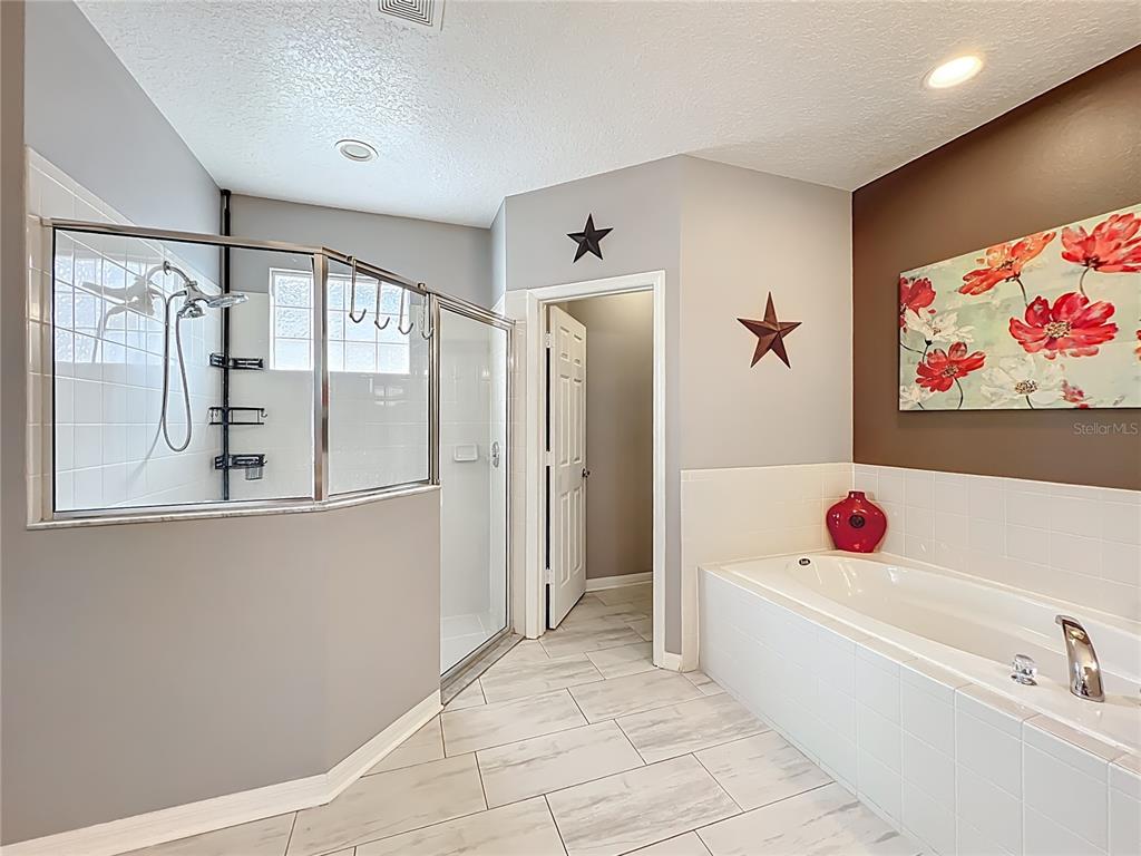 135 Blackstone Creek Road Groveland, FL 34736 - Photo 47 of 62 a bathroom with a tub a sink and a shower