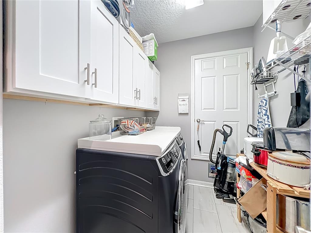 135 Blackstone Creek Road Groveland, FL 34736 - Photo 48 of 62 a utility room with stainless steel appliances washer and dryer