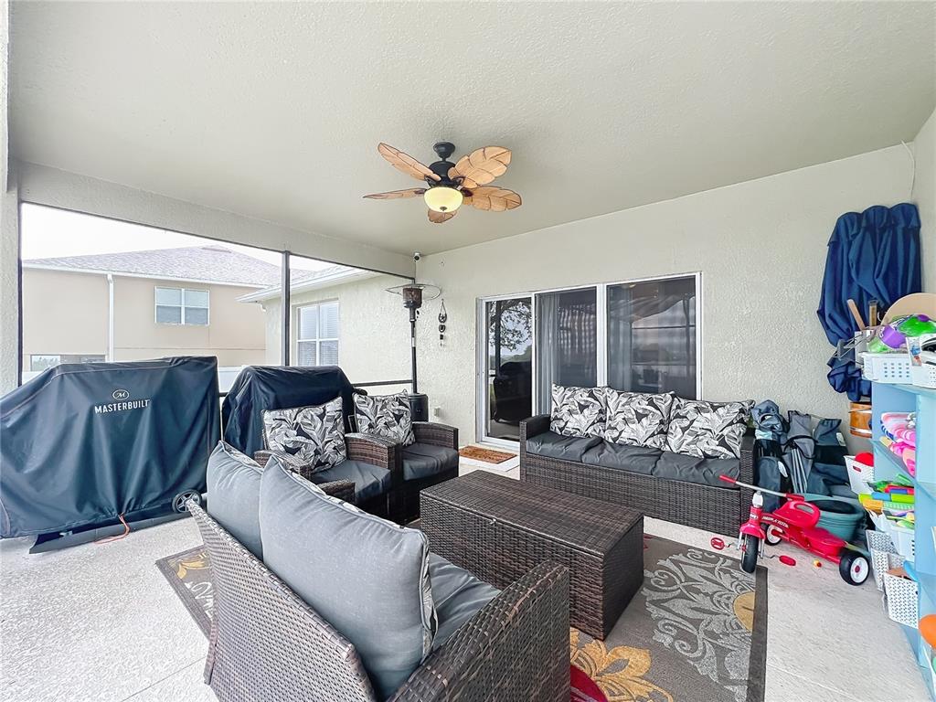 135 Blackstone Creek Road Groveland, FL 34736 - Photo 50 of 62 a living room with furniture flowerpot and a chandelier