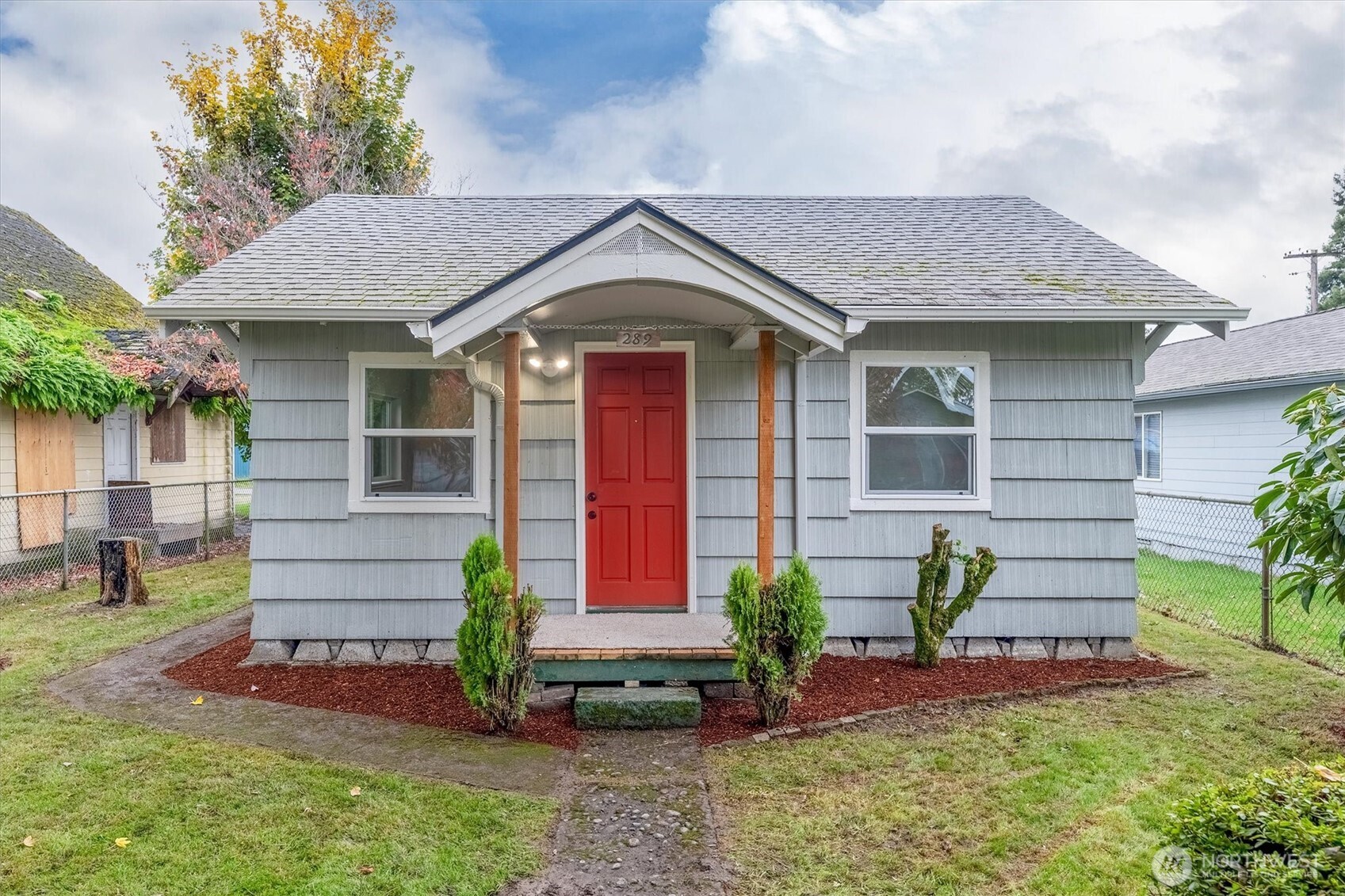 a front view of a house with a garden and plants