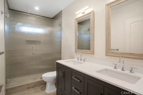 a bathroom with a double vanity sink toilet and a mirror