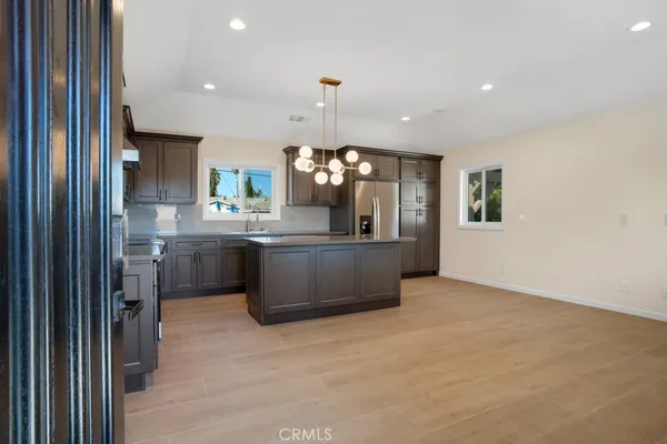 a kitchen with kitchen island a sink stainless steel appliances and cabinets