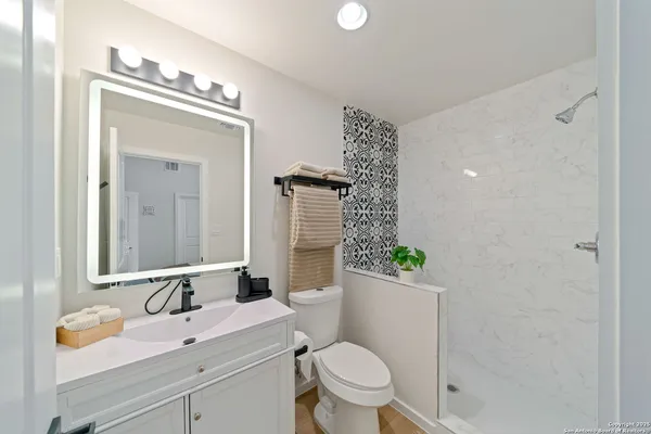 a bathroom with a sink a toilet and mirror