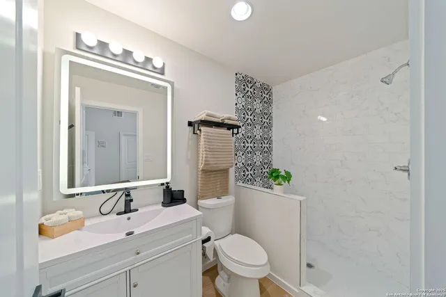 a bathroom with a sink a toilet and mirror