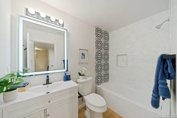 a bathroom with a sink a toilet and a mirror