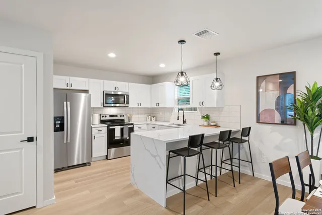 a large kitchen with a table and chairs