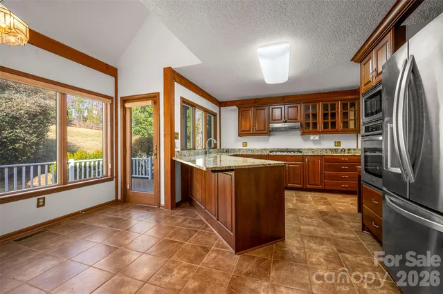 a kitchen with stainless steel appliances granite countertop a stove refrigerator and a sink