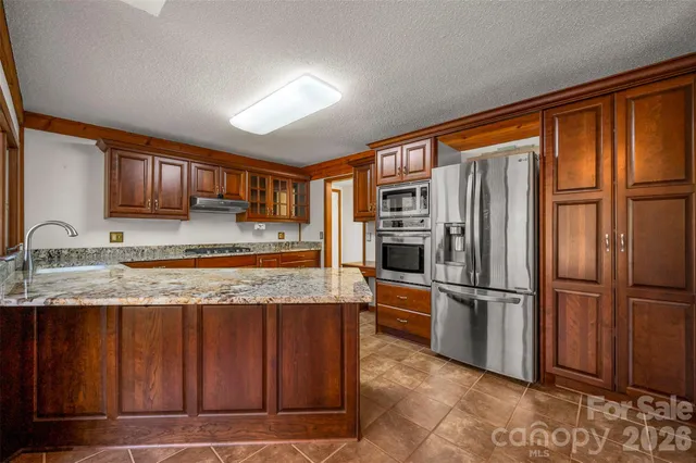 a kitchen with stainless steel appliances granite countertop a refrigerator and a sink