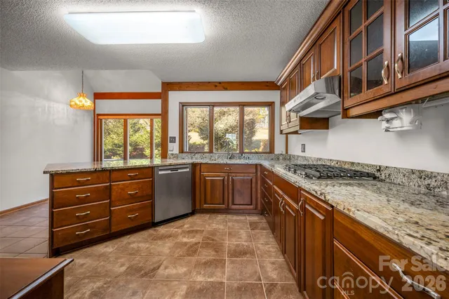 a large kitchen with stainless steel appliances granite countertop a stove and a sink
