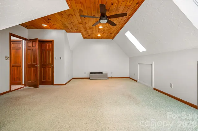 an empty room with a ceiling fan and window