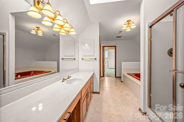 a spacious bathroom with a tub sink and mirror