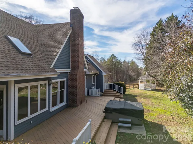 a view of a deck with wooden floor and fence next to a yard