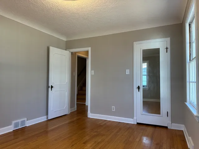 an empty room with wooden floor and closet