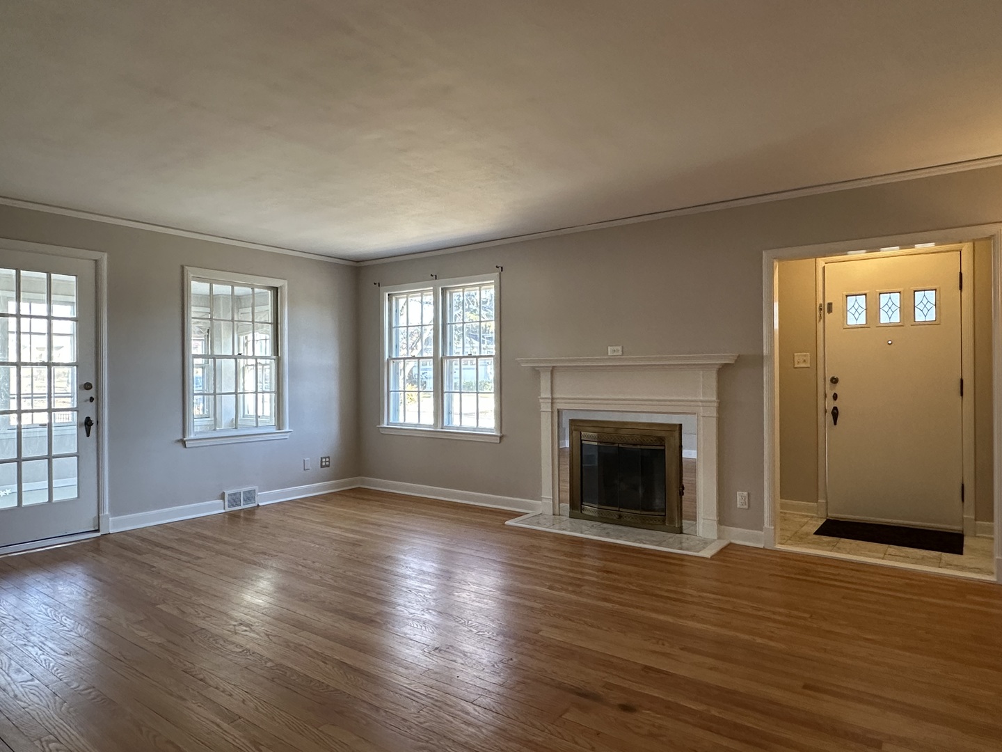 1195 South Myrtle Avenue Kankakee, IL 60901 - Photo 6 of 38 an empty room with wooden floor fireplace and windows