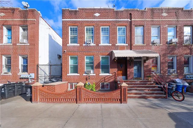 front view of a brick building with a bench in front of building