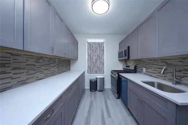a kitchen with a sink dishwasher stove and cabinets