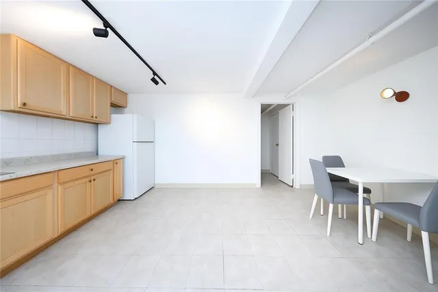 a kitchen with stainless steel appliances granite countertop a sink refrigerator and cabinets