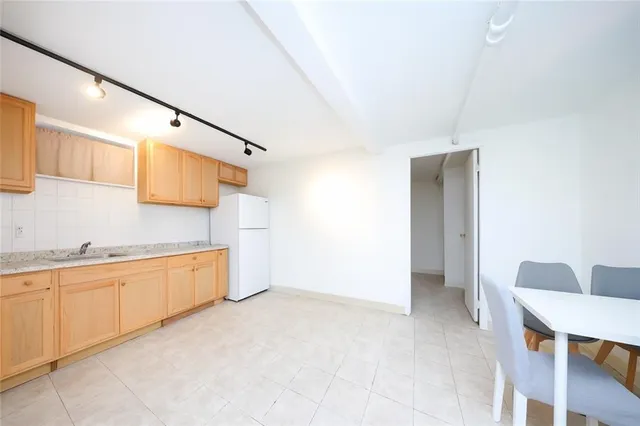 a large white kitchen with a sink and cabinets