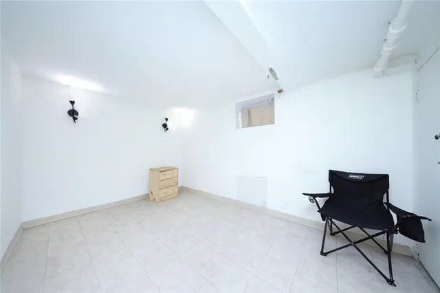 a room with a chair and white wall