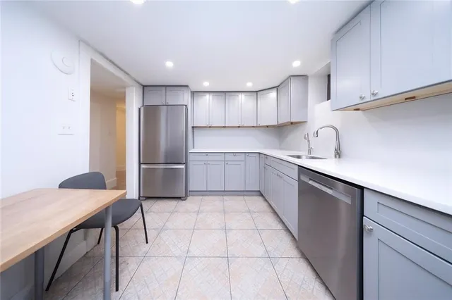 a kitchen with stainless steel appliances granite countertop a sink and a refrigerator