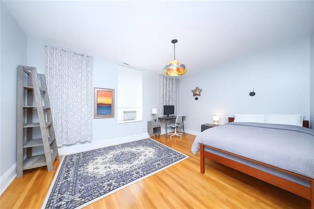 a bedroom with a bed and a wooden floor