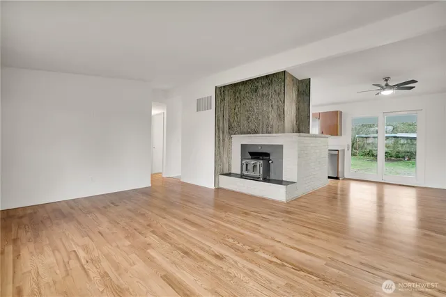 a view of empty room with wooden floor and fireplace