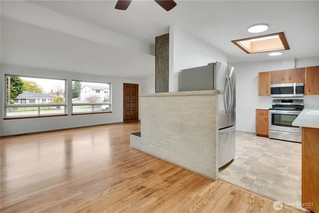 a kitchen with granite countertop a refrigerator and a stove top oven