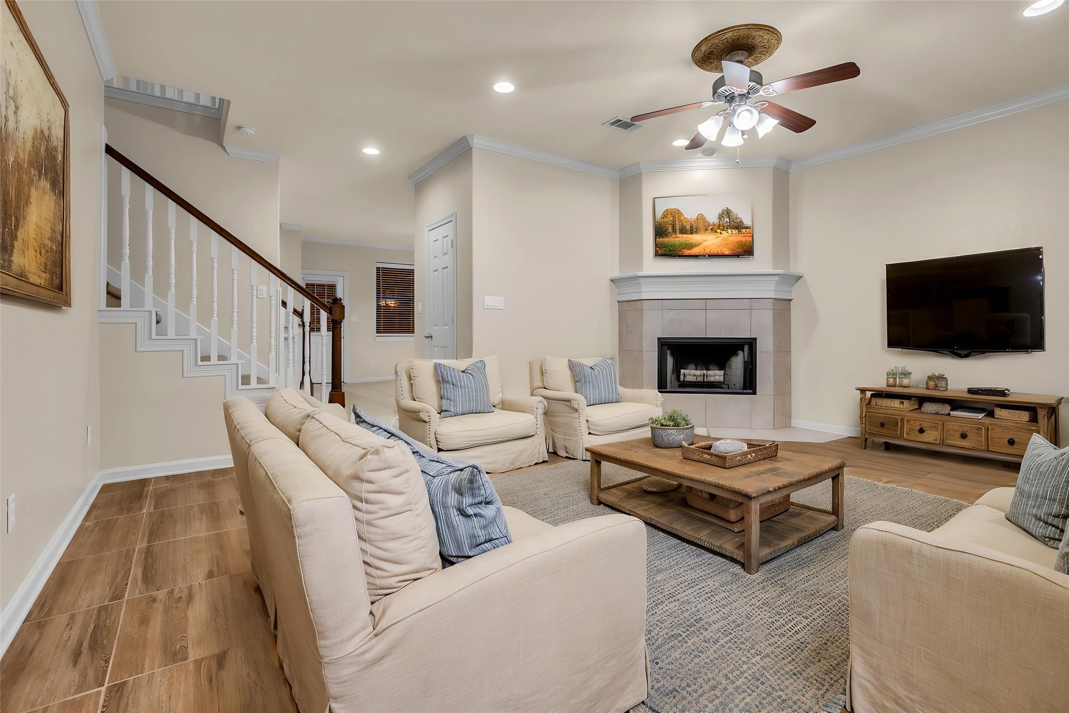 1898 Longmire Road, Unit 5 Conroe, TX 77304 - Photo 12 of 48 This virtually staged living room offers a warm and inviting ambiance with its cozy fireplace, elegant furnishings, and seamless open layout, perfect for comfortable family gatherings.