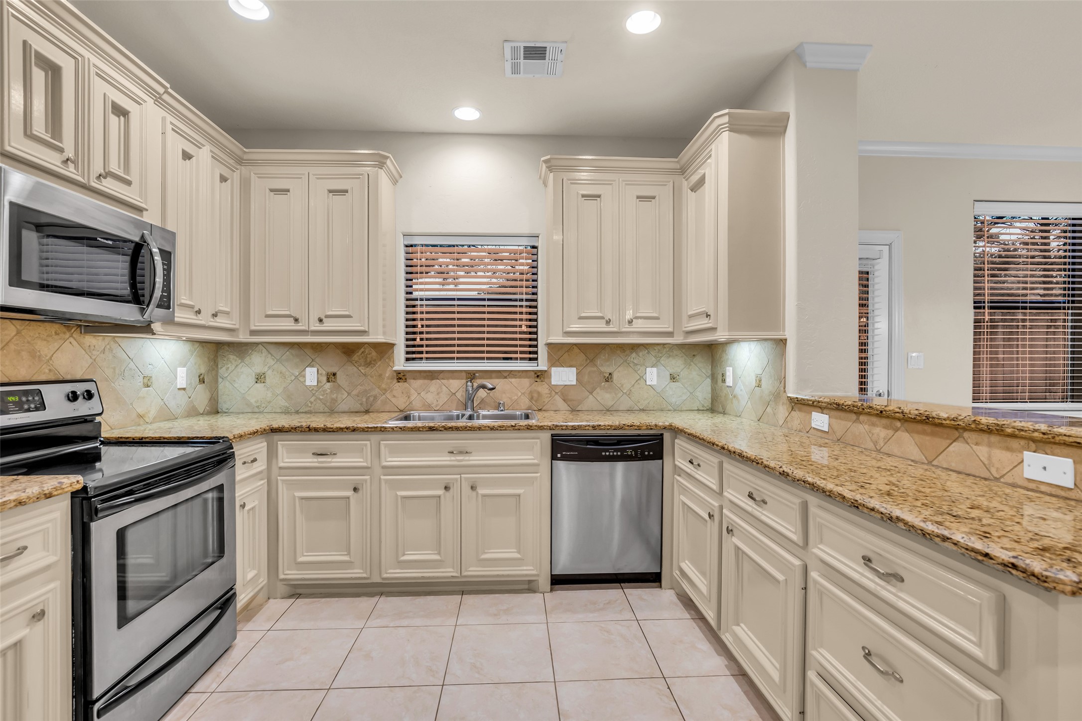 1898 Longmire Road, Unit 5 Conroe, TX 77304 - Photo 17 of 48 a kitchen with granite countertop cabinets stainless steel appliances a sink and dishwasher