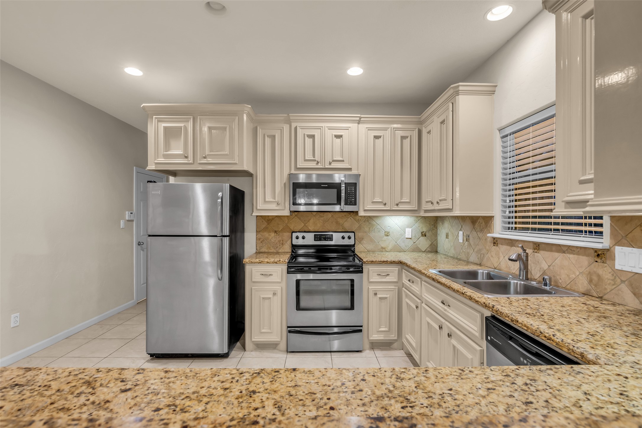 1898 Longmire Road, Unit 5 Conroe, TX 77304 - Photo 20 of 48 a kitchen with stainless steel appliances granite countertop a refrigerator sink and stove