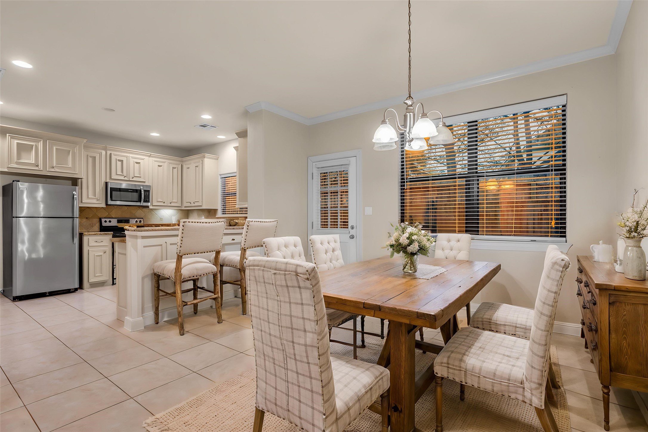 1898 Longmire Road, Unit 5 Conroe, TX 77304 - Photo 4 of 48 This virtually staged home features a warm, inviting kitchen and dining area with elegant cabinetry, modern appliances, and a cozy dining setup perfect for family gatherings.