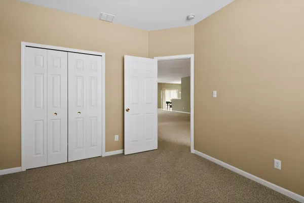 an empty room with closet and a bathroom