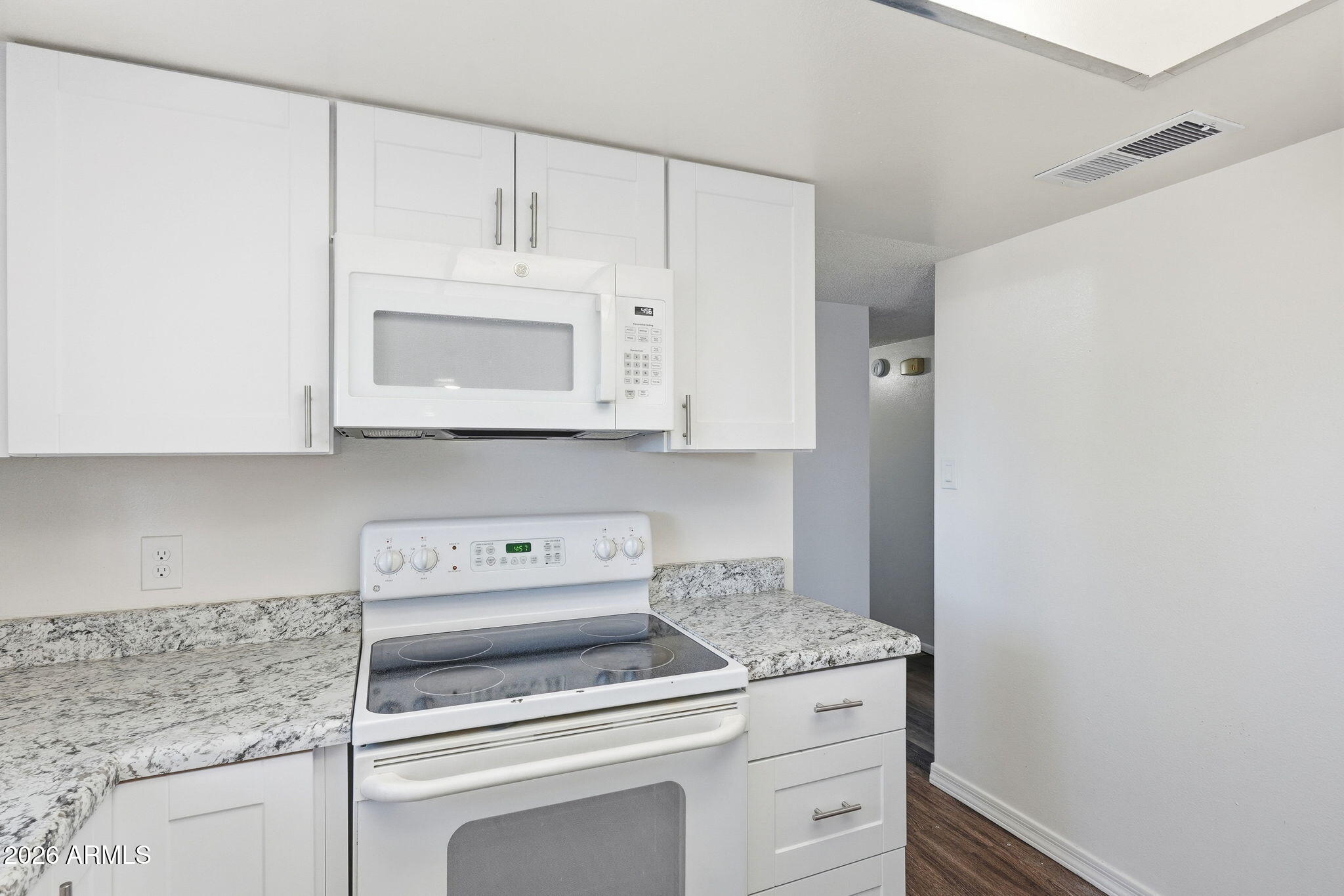 2302 East Nisbet Road Phoenix, AZ 85022 - Photo 8 of 22 a kitchen with granite countertop white cabinets and white appliances