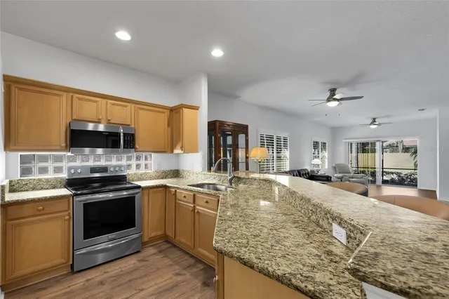 a kitchen with stainless steel appliances granite countertop a sink stove and refrigerator