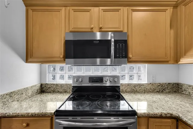 a kitchen with granite countertop white cabinets and stainless steel appliances