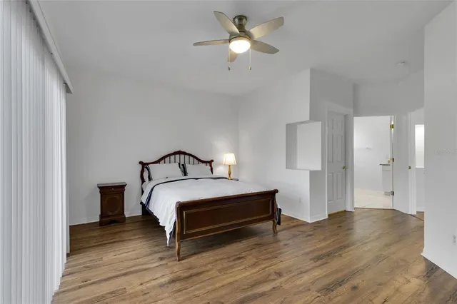 a spacious bedroom with a bed and a ceiling fan