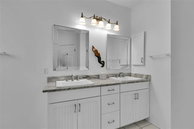 a bathroom with a granite countertop sink double and mirror