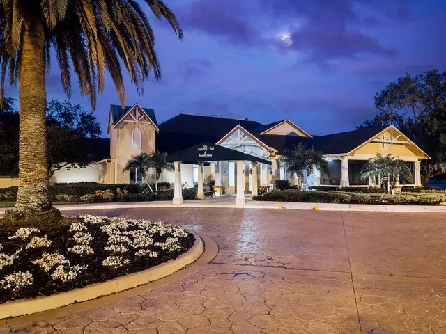 a kitchen with stainless steel appliances granite countertop a stove a sink a dining table and chairs with wooden floor