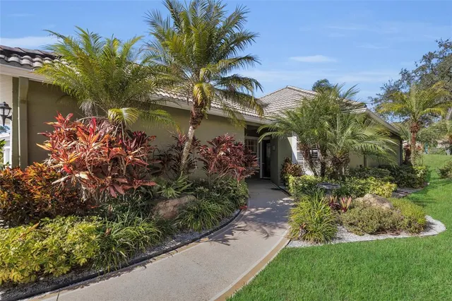 a front view of a house with a yard and garden