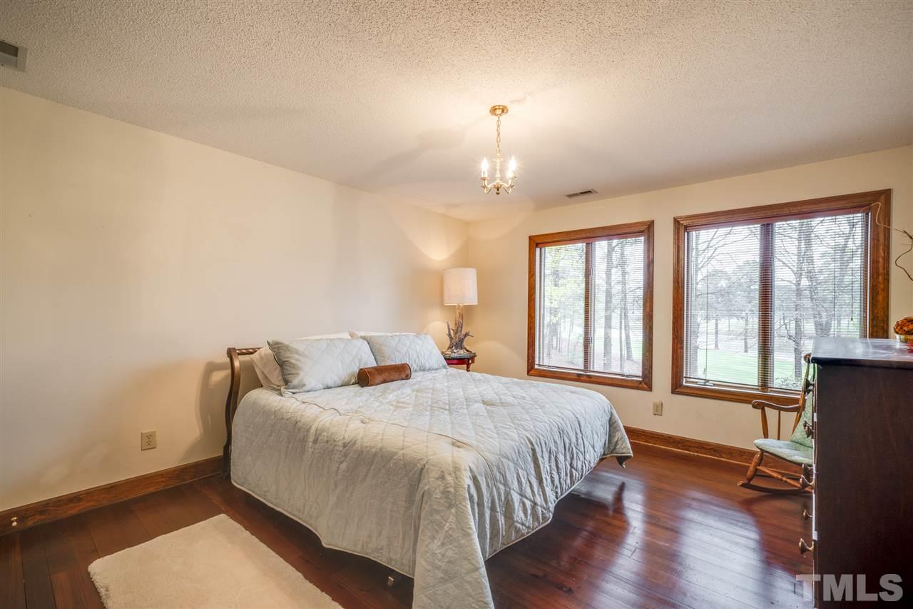 7720 Harps Mill Road Raleigh, NC 27615 - Photo 23 of 28 a bedroom with a bed and wooden floor