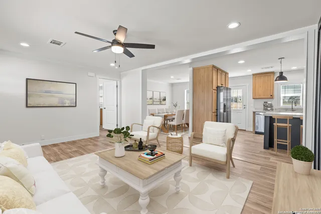 a living room with furniture kitchen view and a chandelier