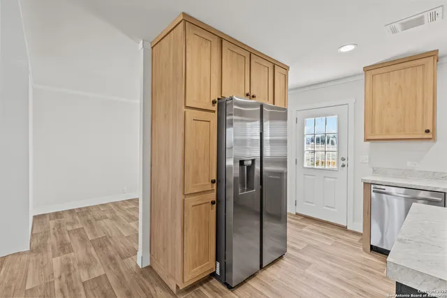 a view of a refrigerator in kitchen and wooden floor