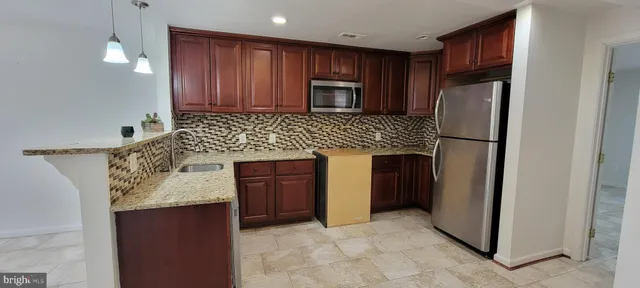 a kitchen with granite countertop stainless steel appliances and wooden cabinets