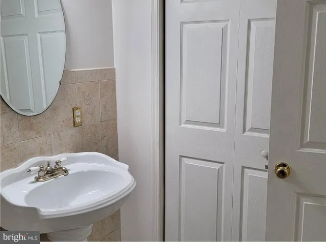 a white bath tub sitting next to a white sink and vanity