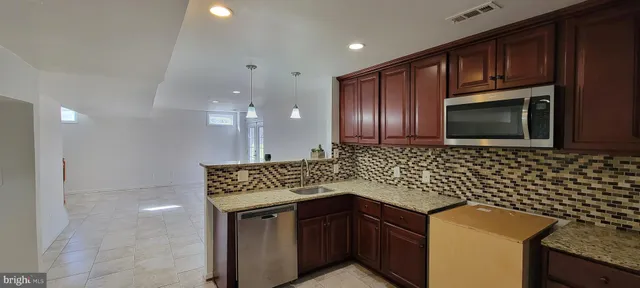 a kitchen with granite countertop stainless steel appliances a stove sink and microwave