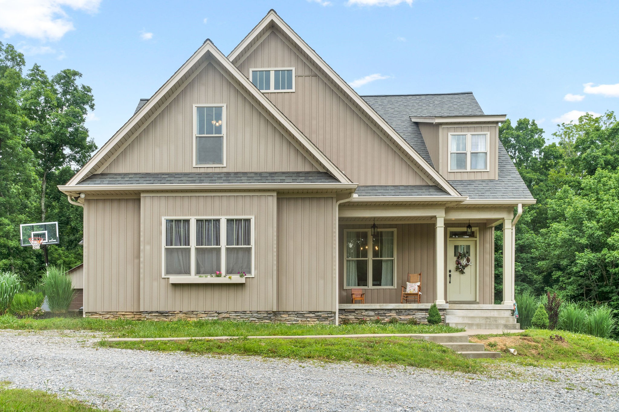 a front view of a house with a garden and trees