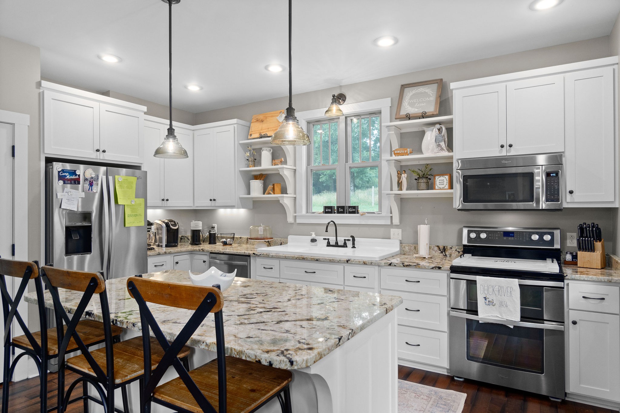1855 Tottys Bend Road Duck River, TN 38454 - Photo 17 of 46 a kitchen with stainless steel appliances kitchen island granite countertop a stove a sink and a microwave