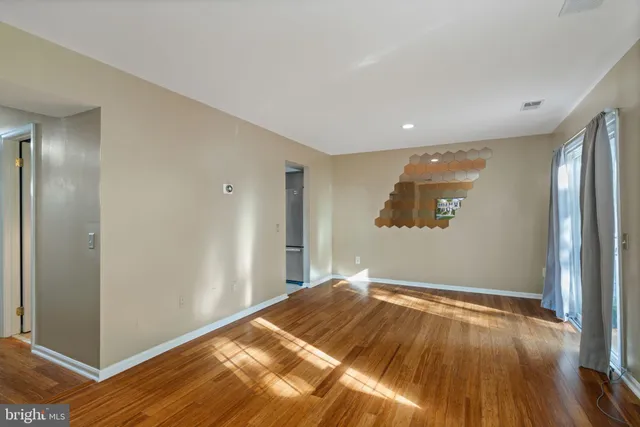 a view of a big room with wooden floor and windows