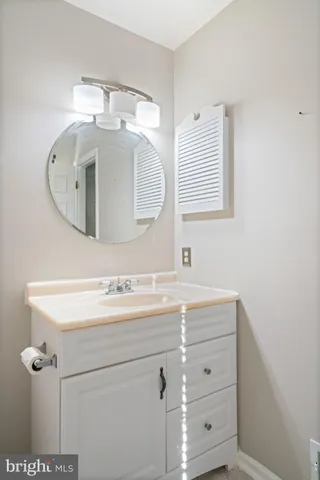 a bathroom with a sink vanity and mirror