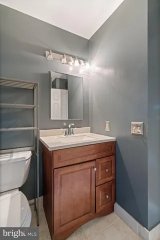 a bathroom with a granite countertop toilet sink and mirror